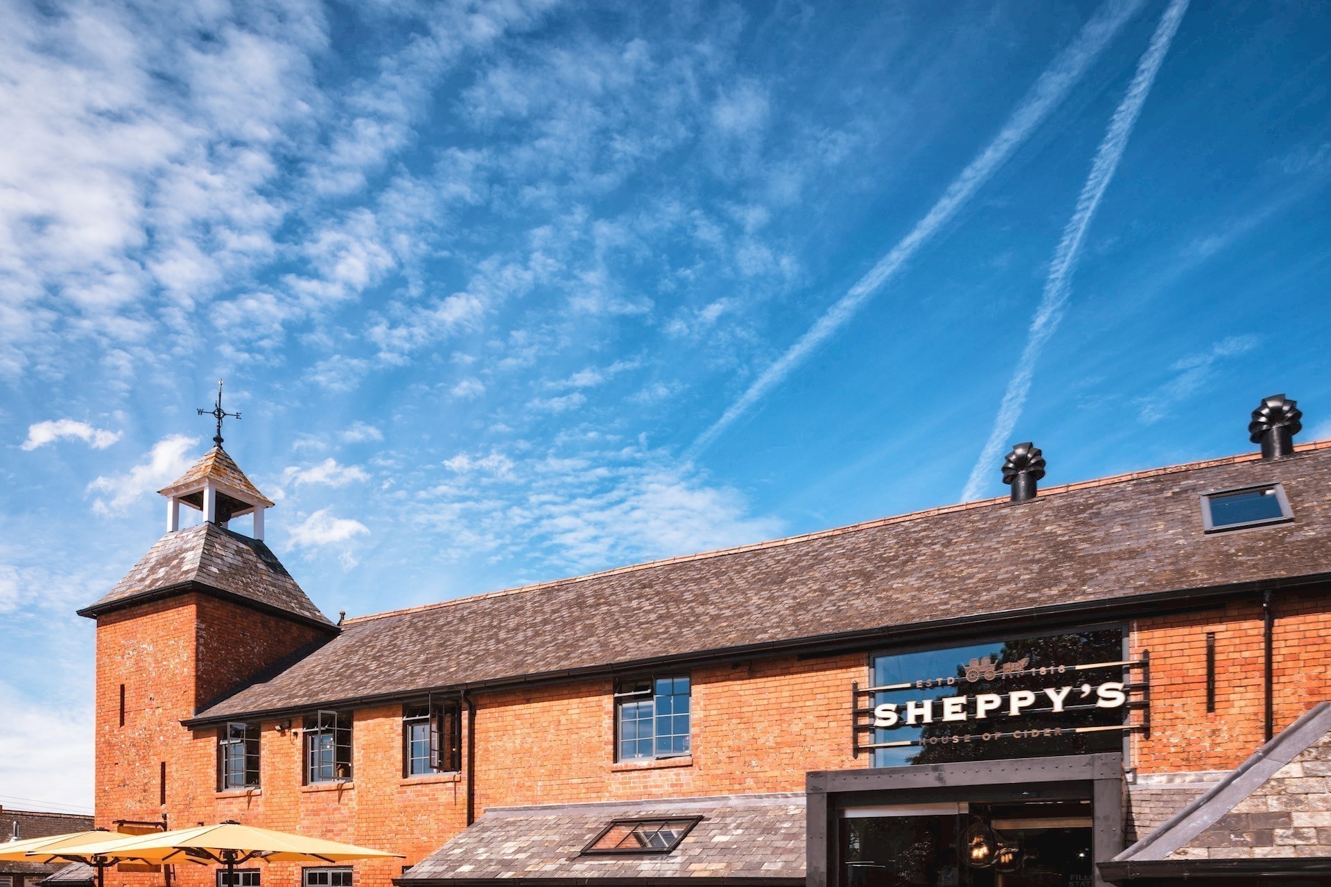 The House of Cider under a wide blue Somerset sky