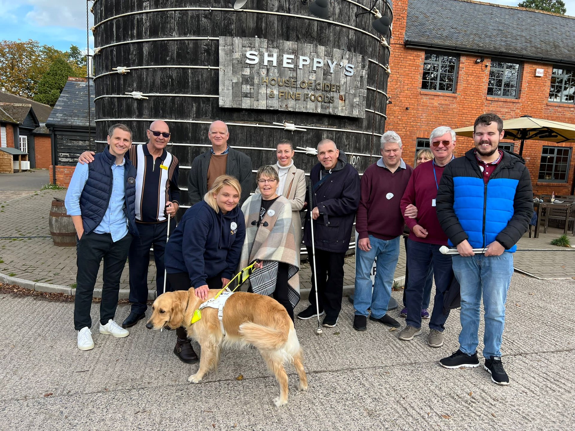 A visiting group in front of the giant painted vat at Sheppy's